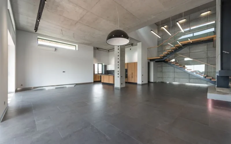 Modern loft style home interior design of spacious hallway with gray stone floor and stairway in contemporary minimalist luxury house