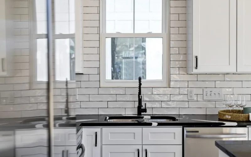 Sleek kitchen with black countertops, white cabinets, and modern design elements.