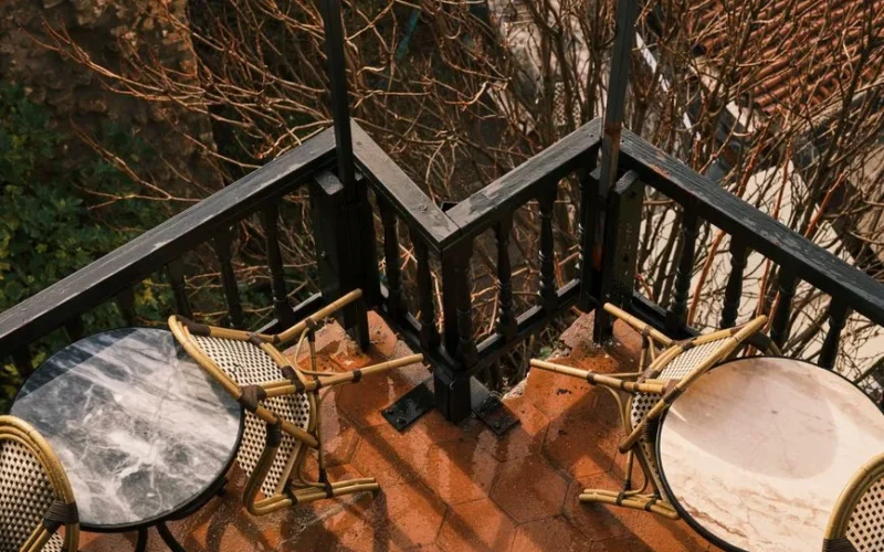Charming balcony with chairs and round tables, perfect for an outdoor retreat.