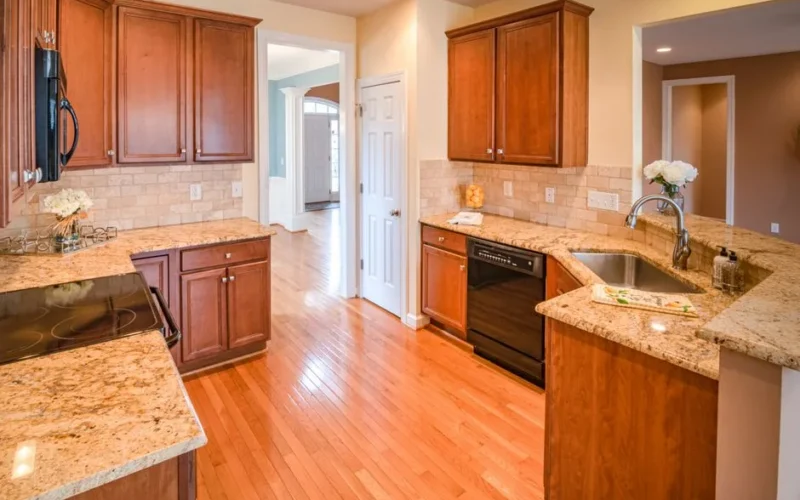 Bright kitchen interior with wooden cabinets and granite countertops.