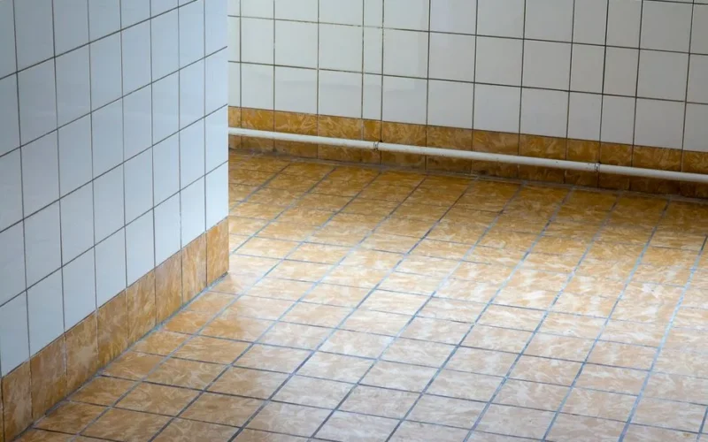 A clean, empty interior space with tiled flooring and walls, showcasing minimalist design.