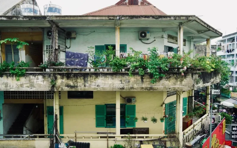 A city balcony adorned with lush plants in an urban residential area.